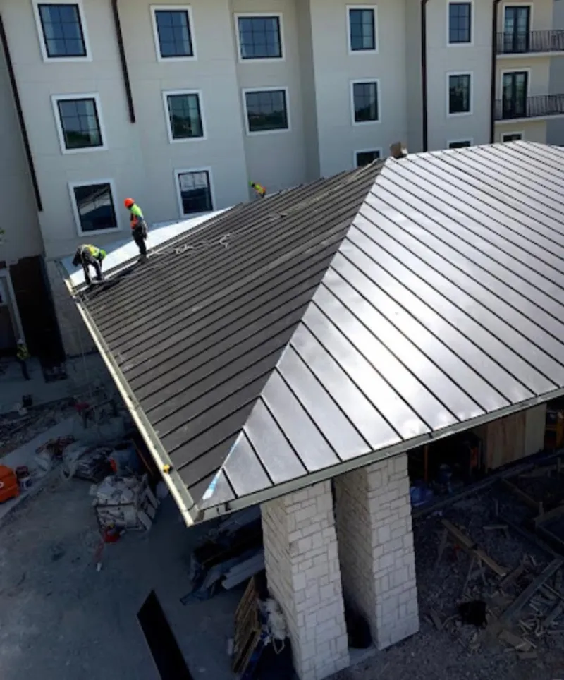 Crew installing standing seam metal roof panels on a commercial project in Fruitland